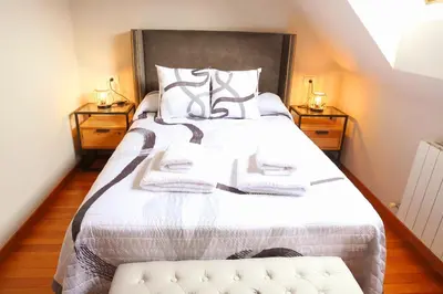 a bedroom with a large bed with two night stands at Arel Dúplex in Lugo