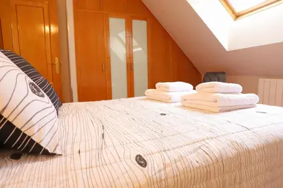 a bedroom with a bed with towels on it at Arel Dúplex in Lugo