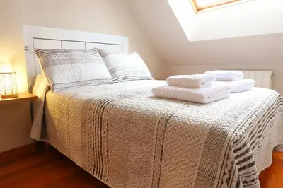 a bedroom with a bed with towels on it at Arel Dúplex in Lugo