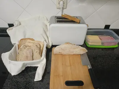 a cutting board with bread and a knife on a counter at Cesuresrooms1 in Puentecesures