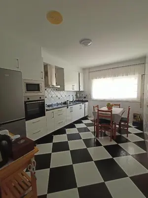 a kitchen with a black and white checkered floor at Cesuresrooms1 in Puentecesures