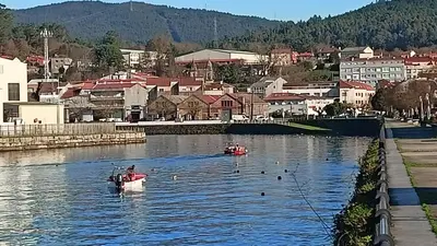 two boats in a river with a town in the background at Cesuresrooms1 in Puentecesures