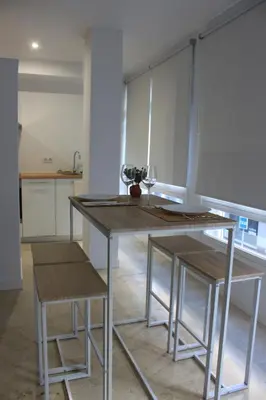 a kitchen with a wooden table and two stools at XELIÑA c in A Estrada