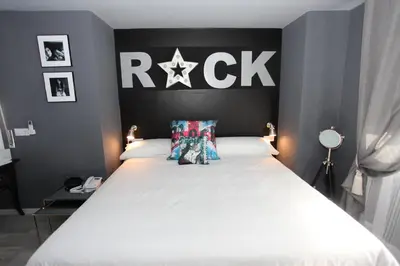a bedroom with a large white bed with a black headboard at Hotel Rock Star in Taboadela