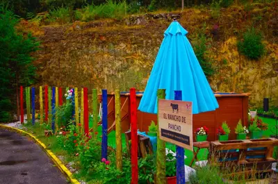 a fence with a blue umbrella and a sign at Hotel Rock Star in Taboadela