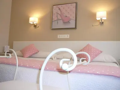 a bedroom with a bed with pink pillows at Hotel el Pinar in Villapedre