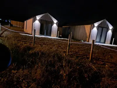 a wooden building at night with lights around it at Cabañas Camiño do Mar in Foz