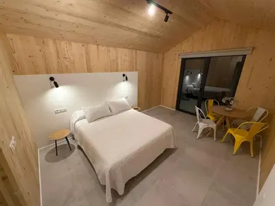 a room with a table with a bed and a bedroom at Cabañas Camiño do Mar in Foz