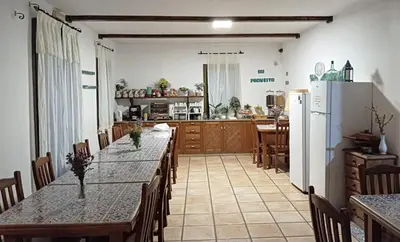 a kitchen with a long table with chairs and a refrigerator at Rural Coliving in Pontevedra