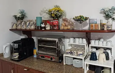 a kitchen counter with a shelf with cups and dishes at Rural Coliving in Pontevedra