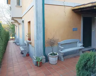 a side walk with benches and potted plants next to a building at Rural Coliving in Pontevedra