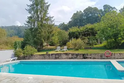 a swimming pool in front of a house at Rural Coliving in Pontevedra