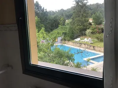 a window with a view of a swimming pool at Rural Coliving in Pontevedra
