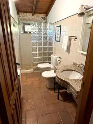 a bathroom with two sinks and a toilet and a window at As Casiñas Bed & Breakfast Porto de Bois in Palas de Rei