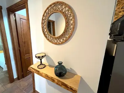 a mirror on a wall with a vase on a counter at As Casiñas Bed & Breakfast Porto de Bois in Palas de Rei