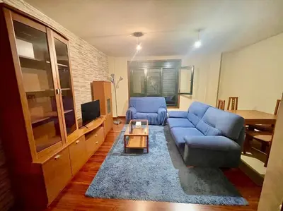 a living room with a blue couch and a table at As Caldas de Mauro in Caldas de Reis