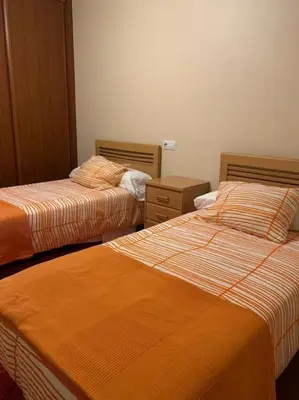 a room with two beds with orange sheets at As Caldas de Mauro in Caldas de Reis