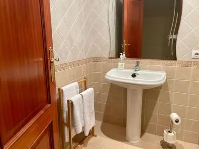 a bathroom with a sink and a mirror and towels at As Caldas de Mauro in Caldas de Reis