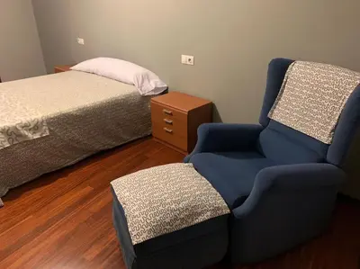 a bedroom with a bed and a chair next to a bed at As Caldas de Mauro in Caldas de Reis