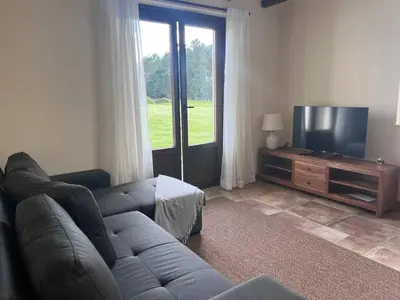 a living room with a couch and a flat screen tv at La Curtía del Neto in El Franco