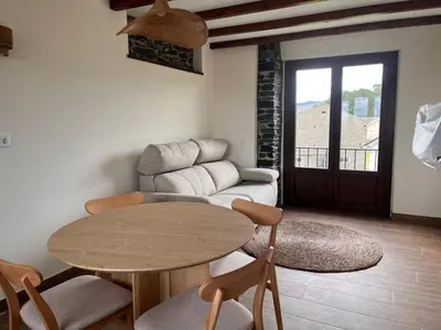 a living room with a table and a couch at La Curtía del Neto in El Franco