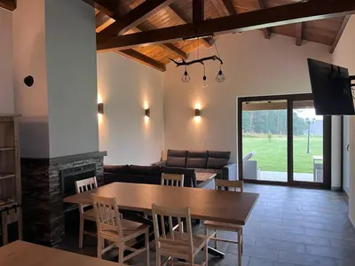 a dining room with a table and a couch at La Curtía del Neto in El Franco