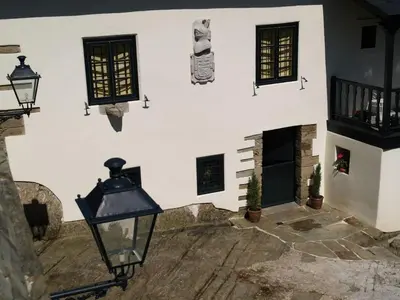 a white building with a fireplace and windows at Pazo Casa Solariega de Cervantes in San Román
