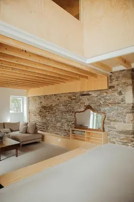 a living room with a couch and a brick wall at Casa de Covés in Puentedeume