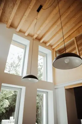 two lights hanging from the ceiling in a room with two windows at Casa de Covés in Puentedeume