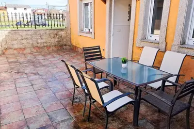 a glass table and chairs on a patio at Carmela House in Melide