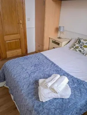 a bedroom with a bed with two towels on it at Carmela House in Melide