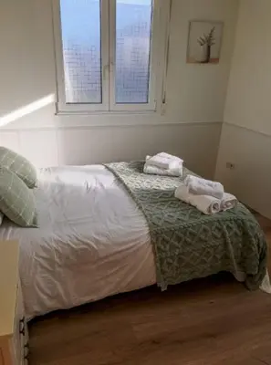 a bedroom with a bed with two towels on it at Carmela House in Melide