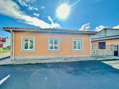 a small orange house with the sun in the sky at Carmela House in Melide