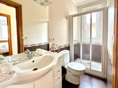 a white bathroom with a toilet and a sink at Carmela House in Melide