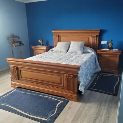 a bedroom with a large wooden bed and blue walls at Casa Viqueira in Foz