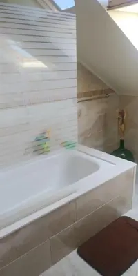 a white bath tub in a bathroom with a staircase at Casa Viqueira in Foz
