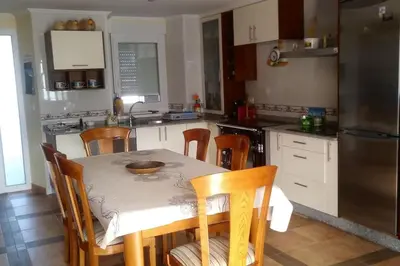 a kitchen with a table and chairs and a kitchen with a refrigerator at Casa Viqueira in Foz