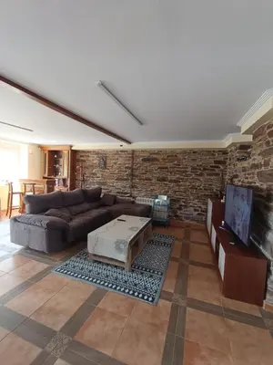 a living room with a couch and a stone wall at Casa Viqueira in Foz