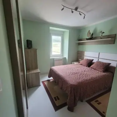 a bedroom with a bed with a pink bedspread and a window at Casa Viqueira in Foz