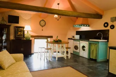 a kitchen and living room with a table and chairs at La Searila in Seares