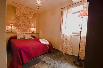 a bedroom with a red bed and a brick wall at La Searila in Seares
