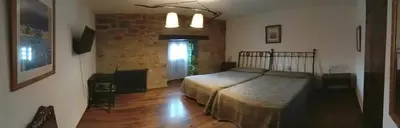 a bedroom with a bed and a brick wall at La Posada de Pedrazales in Pedrazales