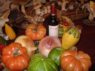 a table topped with lots of vegetables and a bottle of wine at La Posada de Pedrazales in Pedrazales
