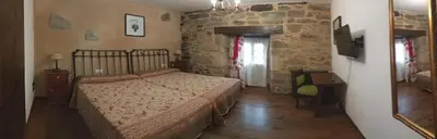 a bedroom with a bed and a stone wall at La Posada de Pedrazales in Pedrazales