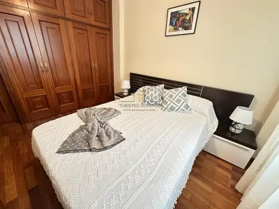 a bedroom with a bed with a white comforter at Balcón da Habana in Ourense