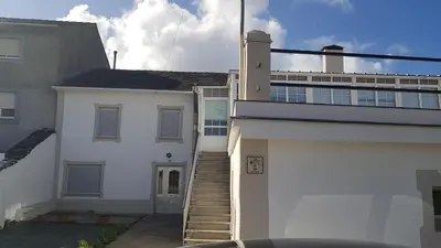 a white house with a stairway next to a building at CASA LOZANO in Barreiros