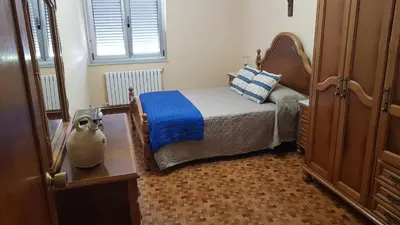 a bedroom with a bed with a blue blanket at CASA LOZANO in Barreiros