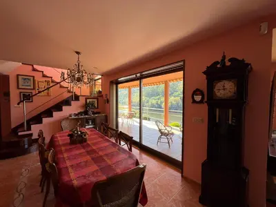 a dining room with a table and a grandfather clock at Casa Río Miño CORTEGADA in Cortegada