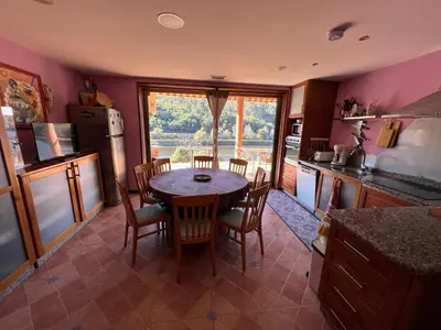 a kitchen with a table and chairs and a kitchen with a window at Casa Río Miño CORTEGADA in Cortegada