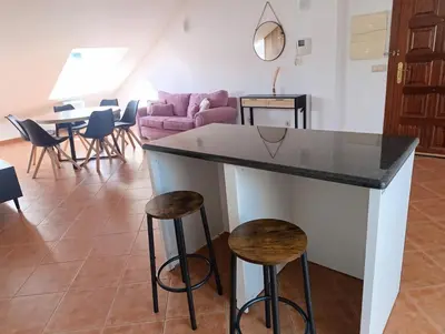 a kitchen and living room with a counter and stools at Apartamento Rio Gallo II in Cuntis